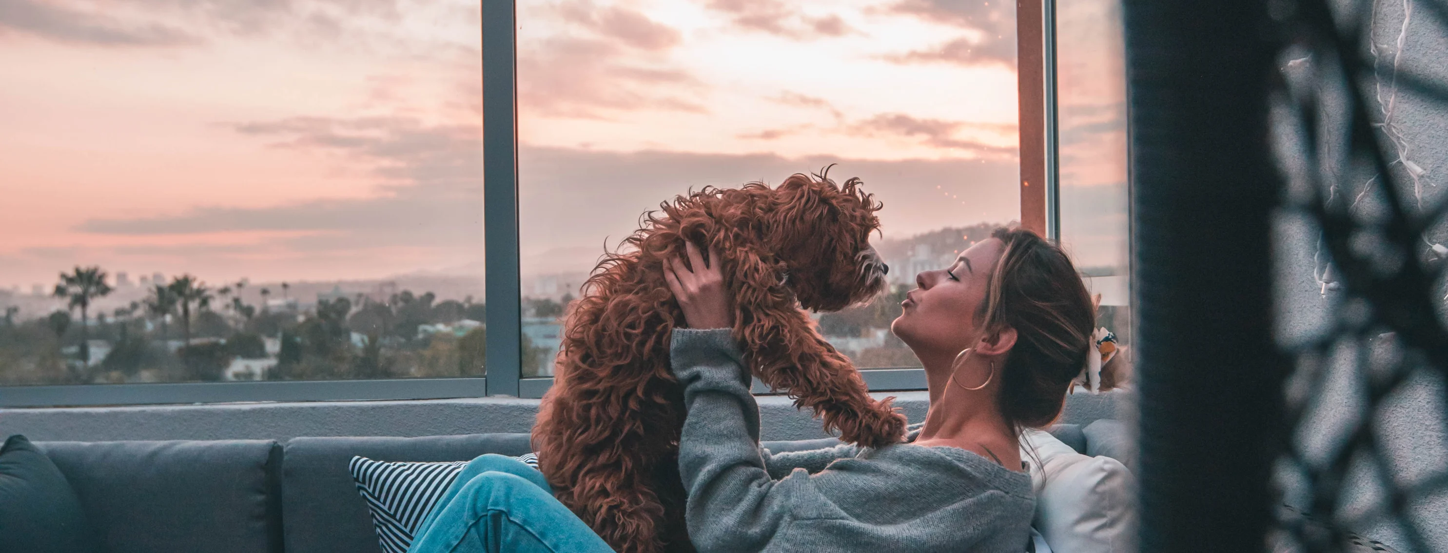 woman holding dog on a balcony couch